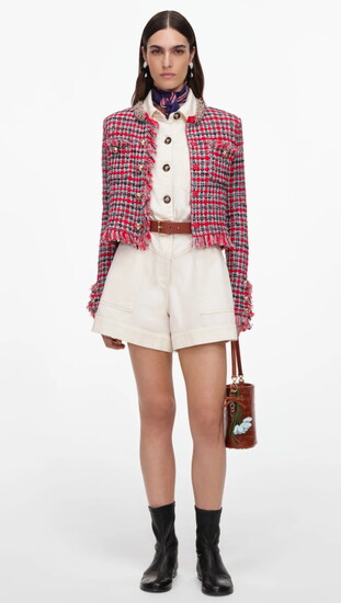 A red checked tweed jacket with embellished buttons and fringe, paired with ivory shorts and black boots