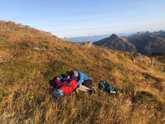Eleanor Knight, then 15, hunkers down from the wind with her siblings, Tilly Jane, 13, and Ivan, 11, atop Kodiak Island’s 2,073-foot Barometer Mountain.