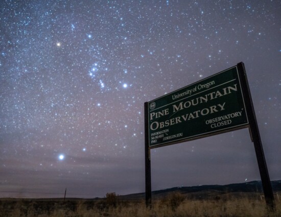 The constellation Orion shines brightly over the Pine Mountain Observatory sign. On the edge of central Oregon, it marks a boundary to unparalleled dark skies.