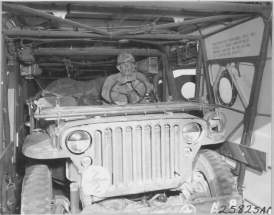 PPC Walter Kivisto, Warren, Ohio, of the Airborne Artillery, backs a Jeep into a CG-4A glider.