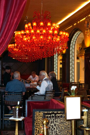 The beautifully appointed Founders Bar with one-of-a-kind red crystal chandeliers. 