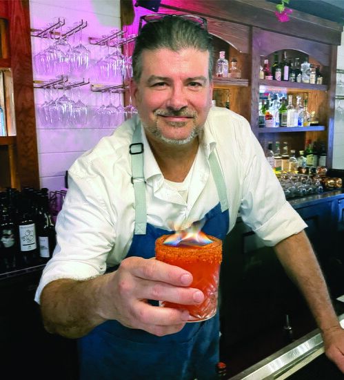 Bartender Leber Fitzpatrick serving a Hades Hellixer