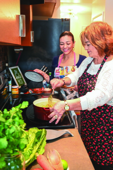 Mom prepares a dish while Gia looks on.