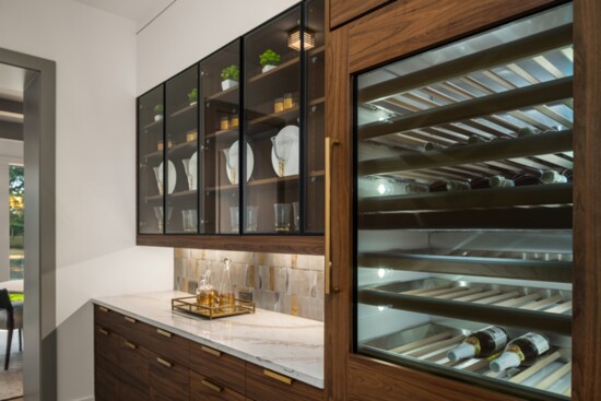 This thoughtfully positioned butler’s pantry, complete with a wine fridge, is strategically placed between the kitchen and dining room. 