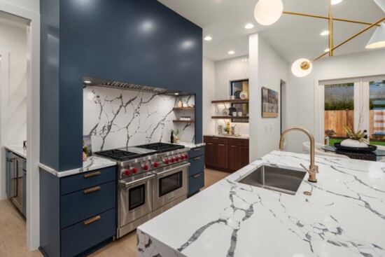 The range alcove features built-in shelving, maintaining a clutter-free environment. The hood alcove extends into the butler’s pantry, connecting the two spaces