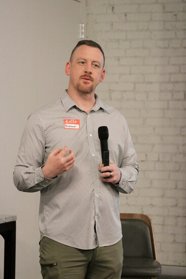 Andrew speaking at a networking event at desk chair workspace