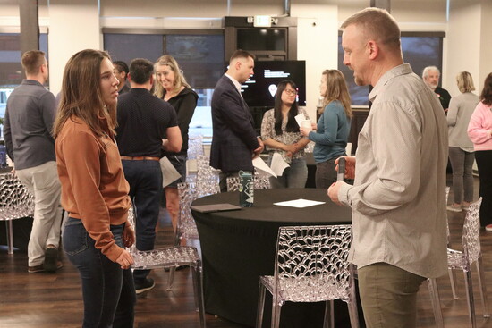 Community members networked at desk chair workspace.