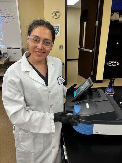Liliana "Gaby" Guzman-Garcia working with a UV-Vis spectrophotometer to measure protein concentration in a sample.