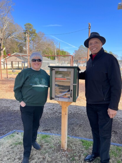 Sally Rhoden with Mayor Ollie Clemons at the ribbon cutting of the Little Free Library she donated to honor her grandchildren.