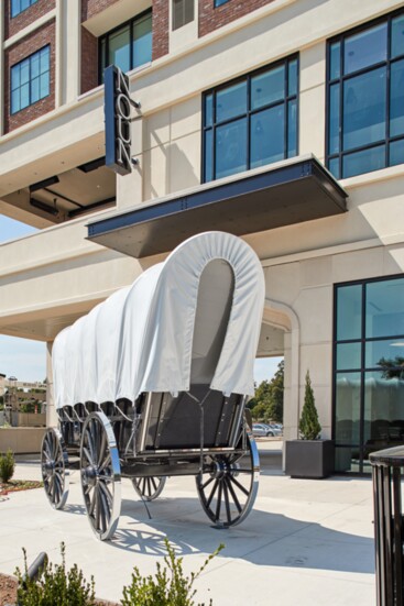 A stylized conestoga wagon (Go, Sooners!) graces the entryway to the NOUN hotel.