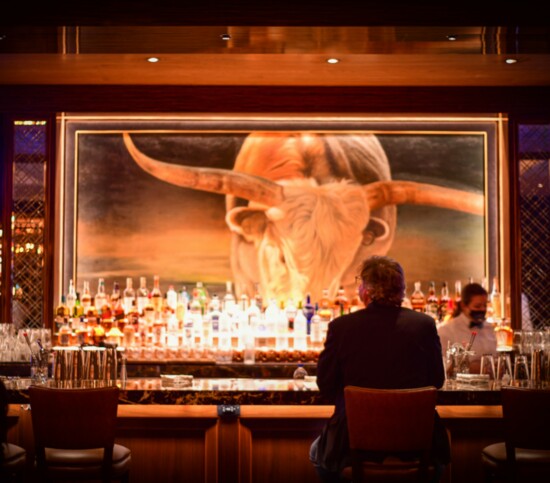 A customer enjoys a drink at the bar of Bob's Steak & Chop House, located in the hotel.