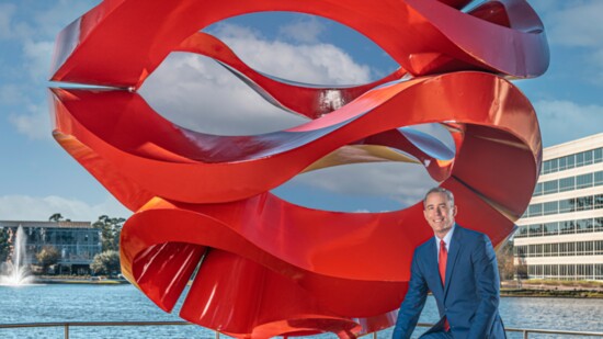 Jim Carman of Howard Hughes-Houston Region, with Wind Waves, his favorite sculpture, which is located in Hughes Landing