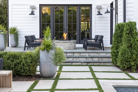 Fire elements, like this cozy fire table and a built-in fireplace, cast a warm glow in the evening.
