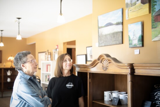 Pam and Joy admire paintings for sale