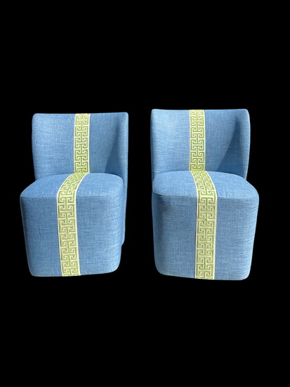 These modern swivel chairs are upholstered in a striking blue performance fabric and finished with an embroidered green-and-white Greek key trim, adding an unex