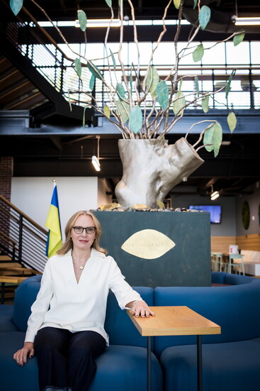 Katie Vigilante, the sculptor of the 'Tree of Kovel' sits in front of the sculpture in Chamblee City Hall.