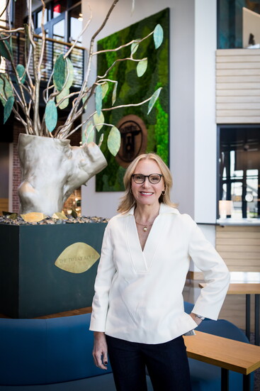Katie Vigilante stands next to her work, 'The Tree of Kovel,' on display in Chamblee City Hall.