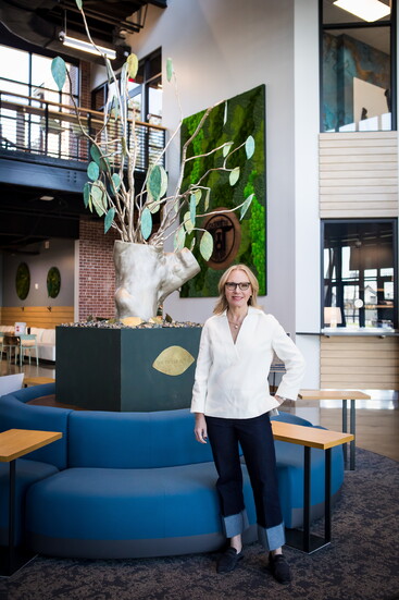 Katie Vigilante stands next to the 'Tree of Kovel' on display in Chamblee City Hall.