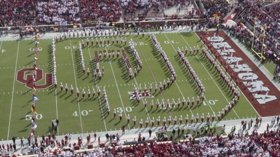 The marching band forms an interlocking OU during a game in 2015.