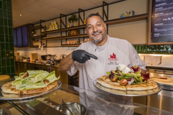 Executive Chef Hany Ali with a pizza salad served at Mercato di Vienza.  Try the roasted chicken and housemade pasta dishes available only on weekends.