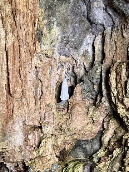 A statue of the Virgin Mary hidden in the walls of a sea cave along the Amalfi Coast shore line.