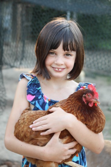 Raegan Ross holds one of the red hens
