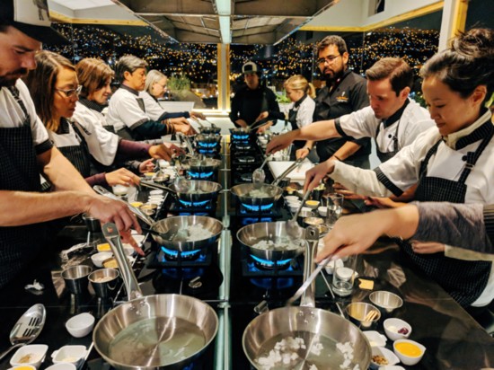 Taste of Peru travelers learning to cook traditional Peruvian dishes in a kitchen overlooking the city of Cusco.