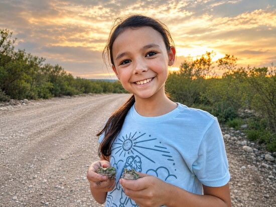 Molly Martin, who grew up around reptiles like her dad, holds one comfortably during a family outing in Texas.
