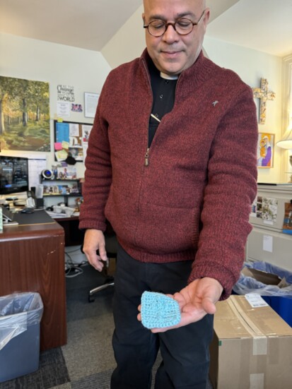 Fr. Daniel Displays a Prayer Square Knitted by a Parishioner as a Gift