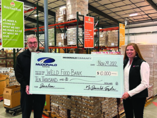 Jessica Zumbrun (right) presents a $10,000 donation to Weld Food Bank CEO, Bob O’Connor