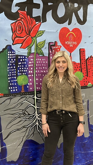 Ashley Freeman poses with a mural of Bridgeport, created by Horizons scholars last summer as part of an annual tradition. By Alicia Cobb.