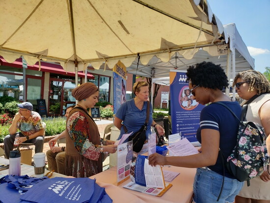 Volunteers engage with the community at the Viva! Vienna! festival to share information about the Center’s vital local services.