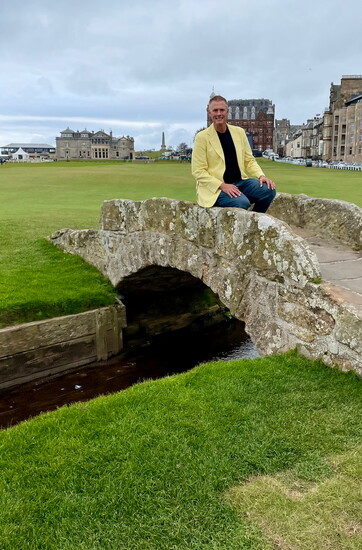 Rick Hontz sits on the famous bridge at St. Andrews, Scotland, birthplace of golf.