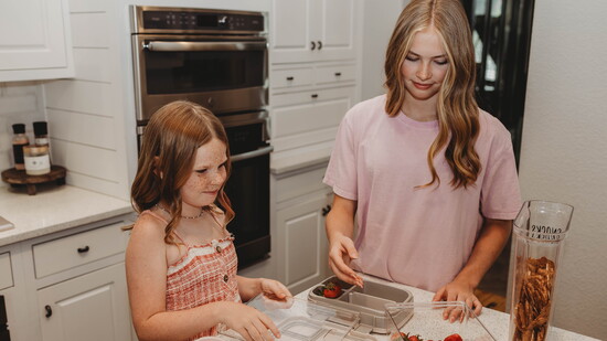 Bento boxes and clear snack containers help Meredith and Taryn Carey make healthy lunch choices easy and fun for school days.