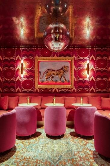 The champagne room encompasses you with patterned Schumacher upholstered walls and a massive disco ball. The painting is by local artist Lee Holiday.