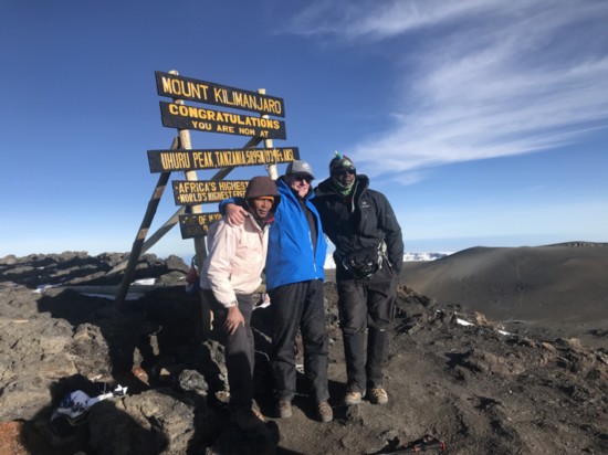 Tim Pagliara poses with guides at the summit of Mount Kilimanjaro.