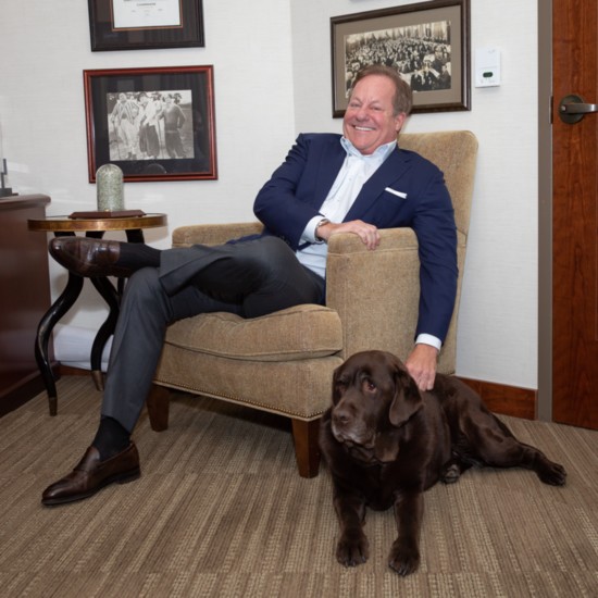 Tim Pagliara, founder of CapWealth, poses in his office with his chocolate lab, Thatcher.