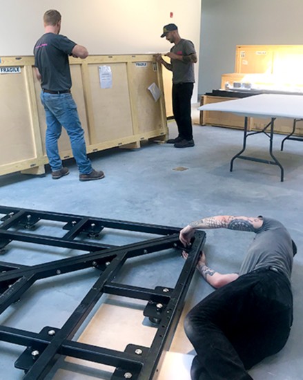 Handlers using hand tools to open the custom crates. Power tools might harm the contents.  (photo: Courtesy MoCA Westport)