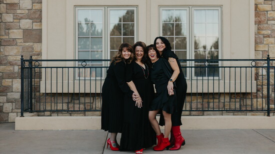 Shawna, Brandy, Jen, and Katherine laugh with each other outside their business