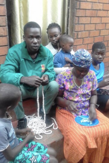 Villagers in Uganda making bracelets