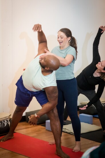 Georgia Lynn, owner of Total Practice Yoga, helps a student with a pose.