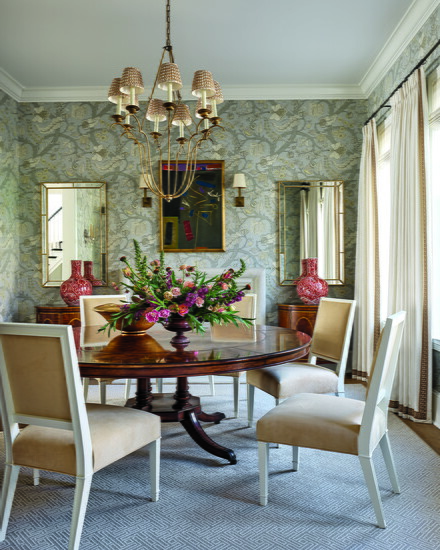 Instead of replacing the dining room chandelier, Fey updated the shades. The abstract painting above the fireplace is by Emerson Woelffer.