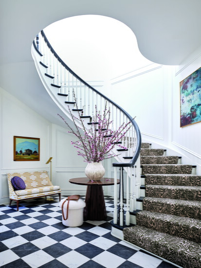 A mid-century settee from 1stDibs, reupholstered in Stroheim fabric, sits beneath artwork by Francis Drexel Smith. The stairwell features a painting by Bernard 