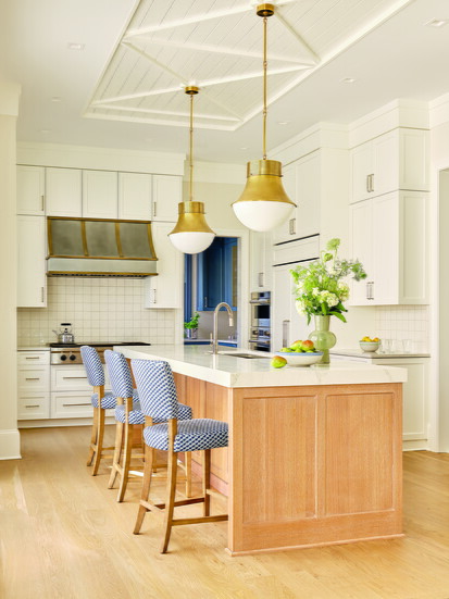 The kitchen cabinets are painted in Benjamin Moore’s Simply White. A mitered edge on the island’s quartz countertops creates the look of a thicker slab.