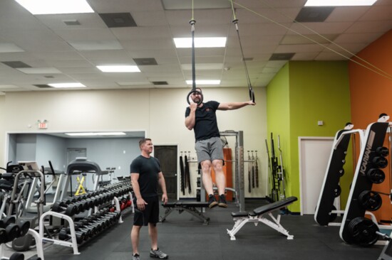 Lee Carter does pullups in the gym.
