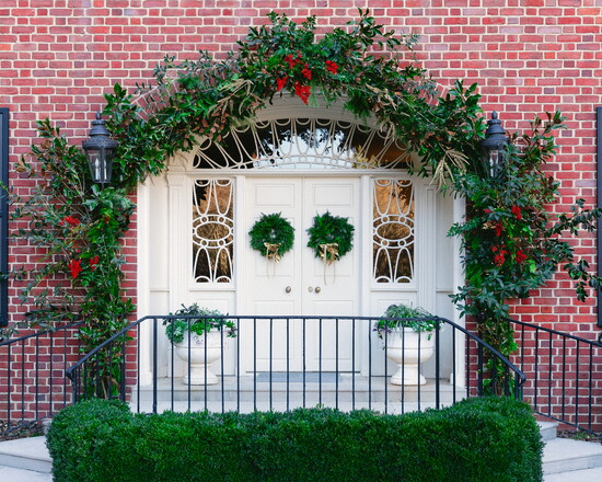 Elevate a wreath or garland around the door by adding fresh boxwood clippings, nandina, or holly berries. “That's one way to give your garland a little more 