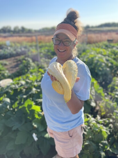 A volunteer proudly displays some of the squash harvest.