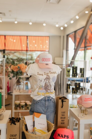 A carefully curated merchandise display topped off with a Goose trucker hat