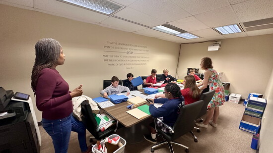 Student volunteers from Christ Methodist Day School assemble reading packets under the direction of Dr. Mouzon.