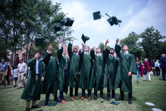 A celebratory moment among graduates on commencement day. 